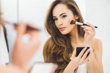 mirror reflection of beautiful young woman applying makeup clipart