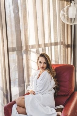 genç ve güzel kadın evde koltukta istirahat bornoz