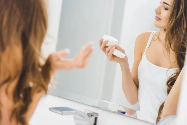 Hermosa Mujer Mirando Crema Facial Mano — Foto de Stock