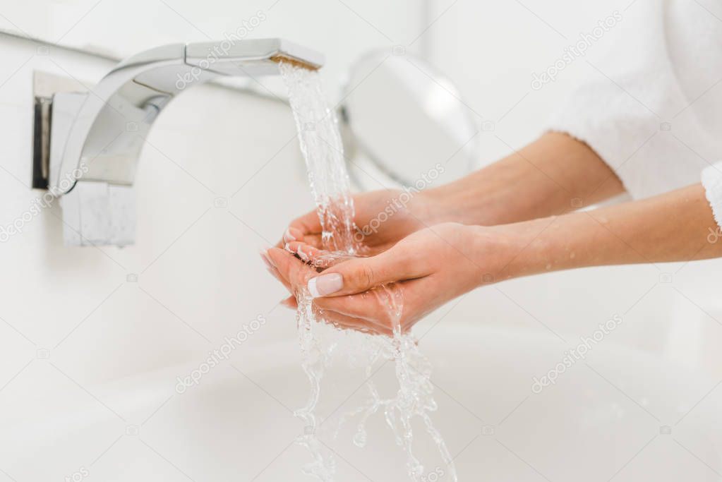 partial view of woman washing hands at home
