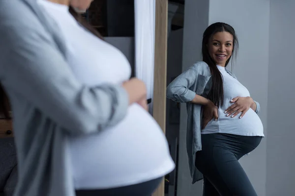 Atrakcyjne African American Kobieta Ciąży Patrząc Jej Brzuch Lustro — Zdjęcie stockowe