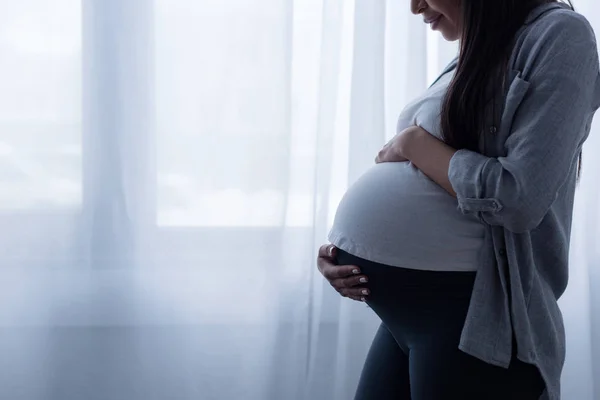 Vue Recadrée Femme Enceinte Touchant Son Ventre Tout Tenant Fenêtre — Photo