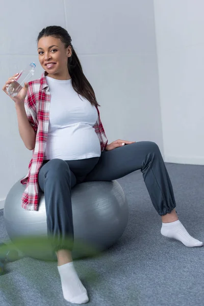 Africano Americano Embarazada Mujer Beber Agua Mientras Sentado Fit Bola — Foto de stock gratis