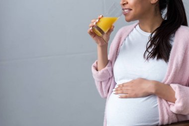 cropped view of african american pregnant woman drinking orange juice  clipart