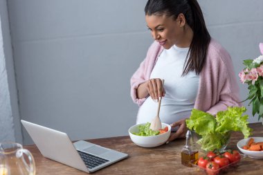 salata çatalı ve laptop arıyorum Afro-Amerikan hamile kadın