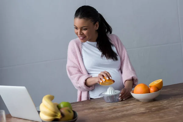 Mulher Grávida Afro Americana Alegre Fazendo Suco Laranja Com Espremedor — Fotografia de Stock Grátis