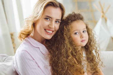 güzel gülümseyen anne ve sevimli kıvırcık kız portresi 