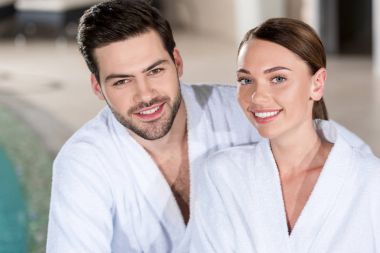 bornoz kamera spa Center'da gülümseyen güzel genç Çift