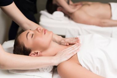selective focus of couple having massage in spa salon