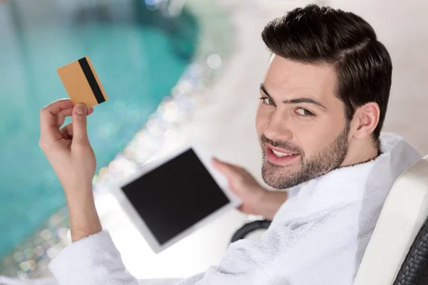 Uśmiechający Się Młody Człowiek Szlafrok Posiadania Karty Kredytowej Cyfrowego Tabletu — Zdjęcie stockowe