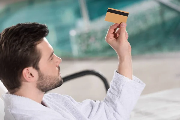 Jovem Bonito Roupão Segurando Cartão Crédito Centro Spa — Fotografia de Stock