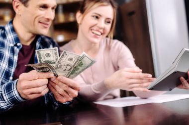 portrait of happy couple counting money together at home clipart