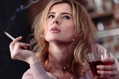 portrait of pensive woman with glass of alcohol and cigarette  clipart