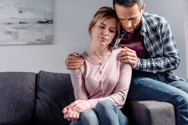 Portrait Man Hugging Upset Woman Sitting Sofa Home — Stock Photo, Image