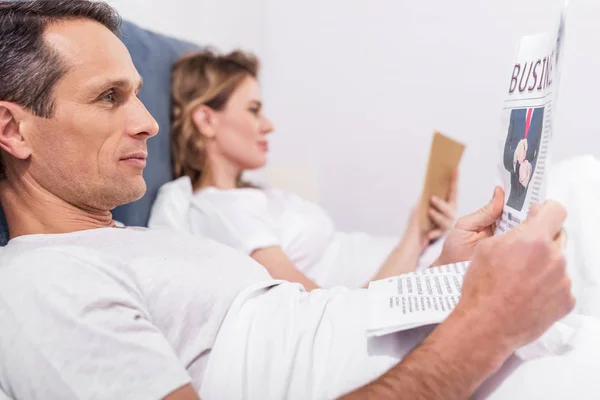 Seitenansicht Paar Liest Zeitung Und Buch Hause Bett — Stockfoto