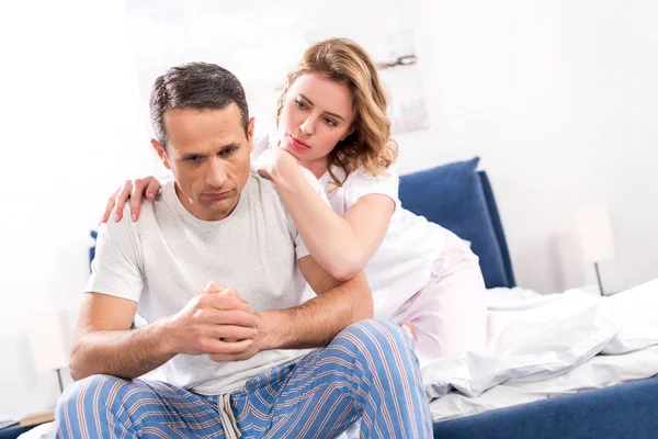 Donna Abbracciare Marito Triste Che Seduto Sul Letto Casa — Foto Stock