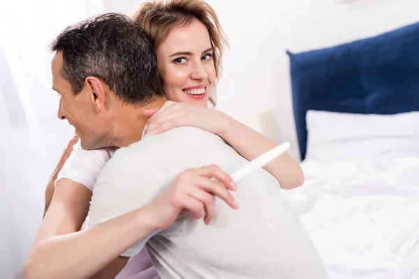 Casal Feliz Com Teste Gravidez Abraçando Uns Aos Outros Casa — Fotografia de Stock