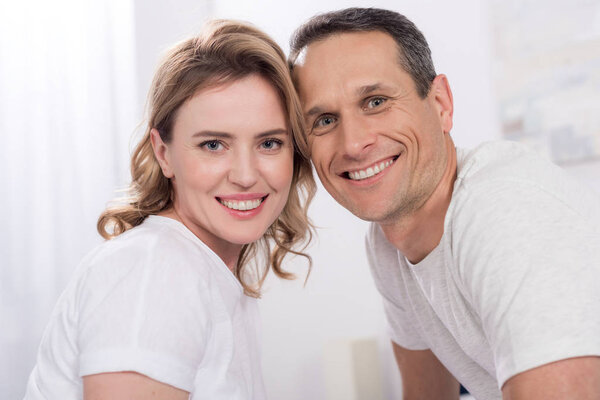 portrait of happy couple looking at camera at home