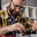 Homme souriant dans des lunettes ordinateur de fixation