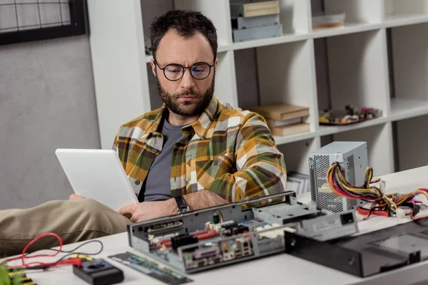 Hombre Usando Tableta Digital Mientras Está Sentado Contra Rota Mesa — Foto de Stock