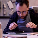 Man in glasses looking on digital tablet on table