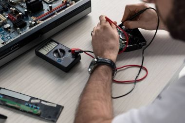 kullanan adam görüntüsünü sabit disk sürücü test ile multimetre kırpılmış