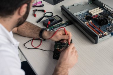 sabit disk sürücü test ederken multimetre kullanan adam kırpılmış görüntü    