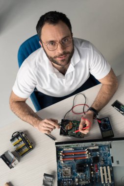 man using multimeter while testing hard disk drive  clipart