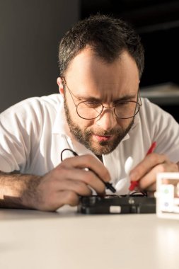 sabit disk sürücü test ederken multimetre kullanan adam   