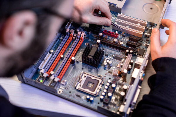cropped image  of man fixing motherboard