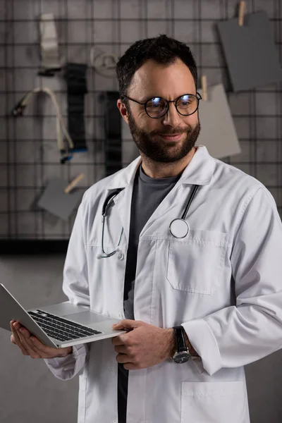 Sorridente Médico Masculino Casaco Branco Com Estetoscópio Sobre Pescoço Segurando — Fotografia de Stock Grátis