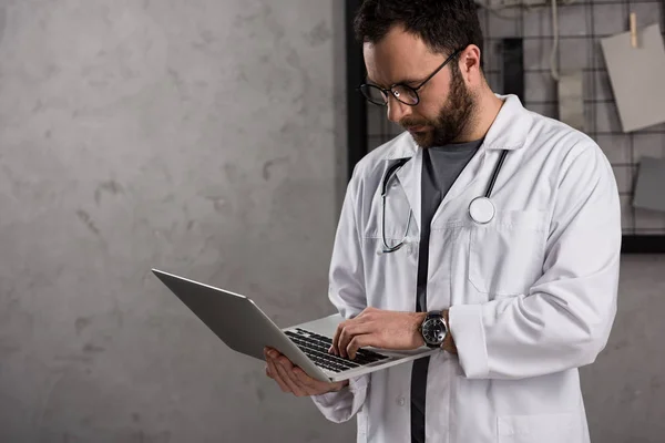 Doctot Białym Płaszczu Stetoskop Nad Jego Szyi Przy Użyciu Laptopa — Zdjęcie stockowe