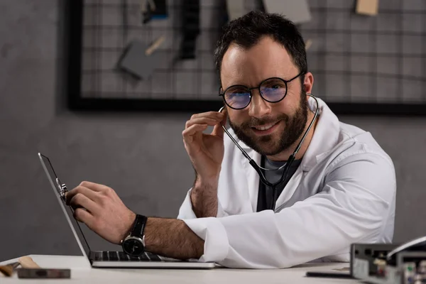 Lächelnder Arzt Weißem Mantel Und Stethoskop Mit Laptop Vor Laufender — Stockfoto