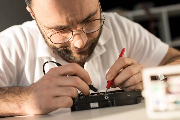 Man Met Multimeter Tijdens Het Testen Van Harde Schijf — Gratis stockfoto