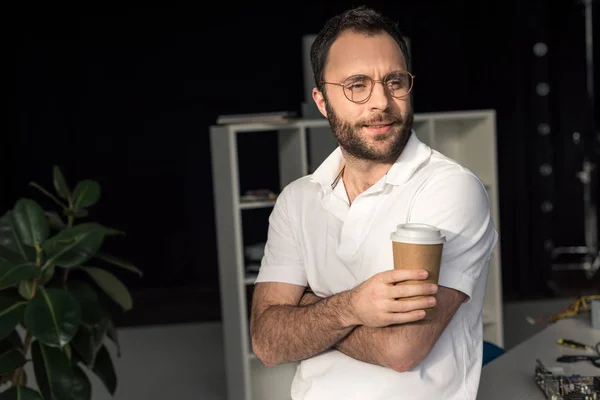 Mand Med Kaffe Hånden Kigger Væk Mens Lænet Bordet - Stock-foto