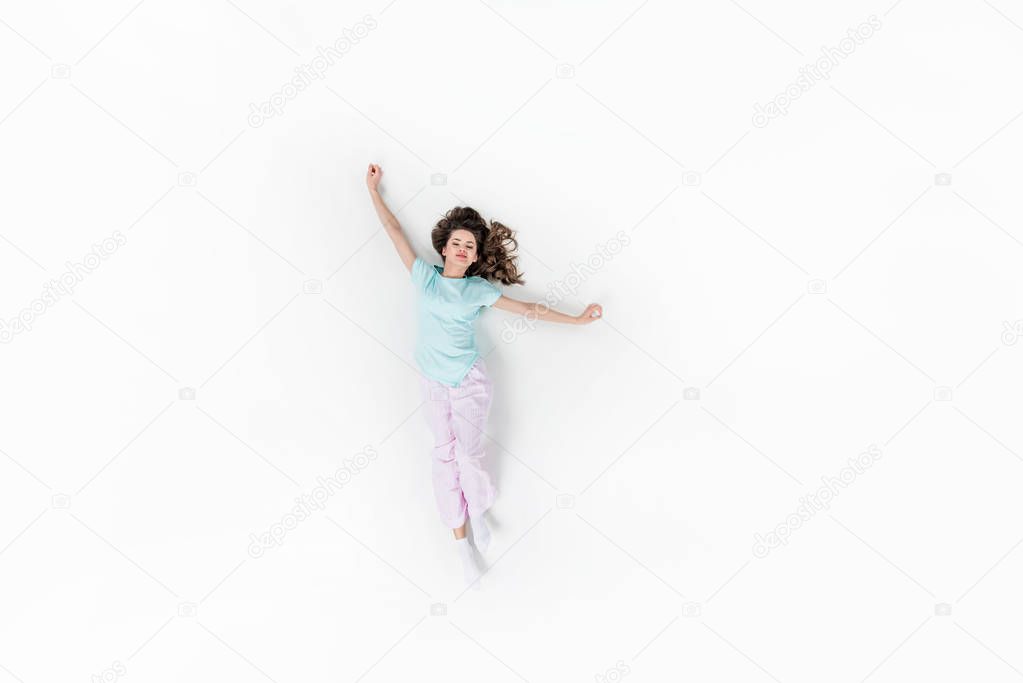 top view of beautiful young woman in pajamas stretching isolated on white