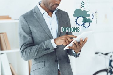 Afrika kökenli Amerikalı adam dijital tablet ve seçenekleri grafiği kullanarak görüntü kırpılmış
