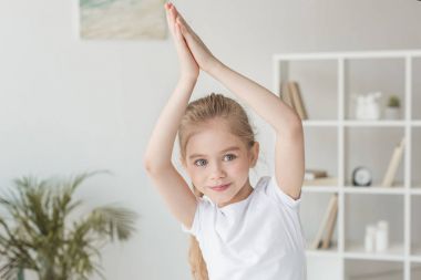 sevimli küçük çocuk Yoga uygulamak ve namaste hareketi yapma