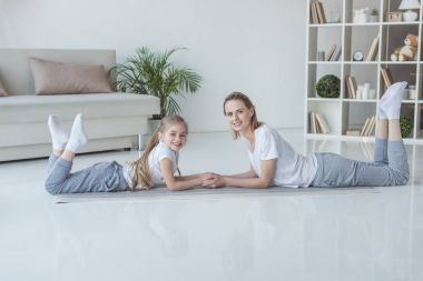 rahat anne ve kızı birlikte yerde yatarken ve kameraya bakıyor