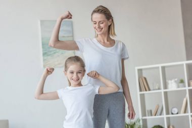 Anne ve kızı pazı kas gösterilen mutlu uygun