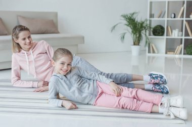 Anne ve kızı kameraya yerde yatarken arıyorsunuz