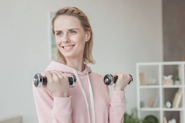 evde dumbell ile çalışma dışarı çekici gülümseyen kadın