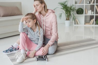 Anne ve kızı yoga mat eğitimden sonra rahatlatıcı bitkin