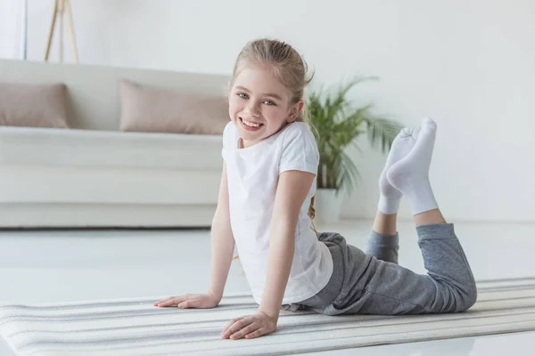 Glückliches Kleines Kind Macht Rückwärtsbeuge Auf Yogamatte Und Schaut Die — Stockfoto