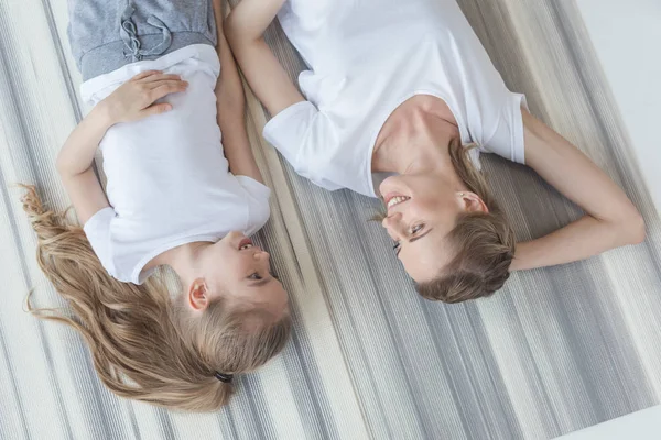 top view of mother and daughter lying on floor