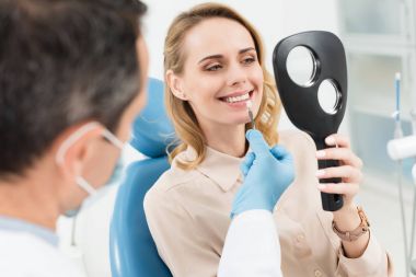Kadın hasta seçimi modern diş Kliniği aynaya bakarak implant diş
