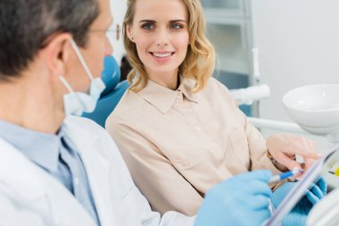 Kadın modern klinik Pano'da bakarak diş hekimi ile danışmanlık