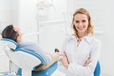 Modern diş Kliniği içinde katlanmış silah ile kadın doktor