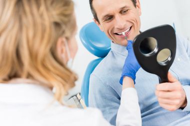Adam modern diş Kliniği aynaya bakarak diş implant seçimi