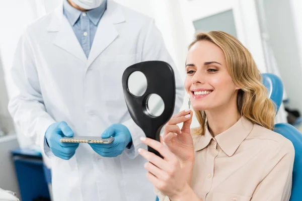 Woman Choosing Tooth Implant Looking Mirror Modern Dental Clinic — Stock Photo, Image